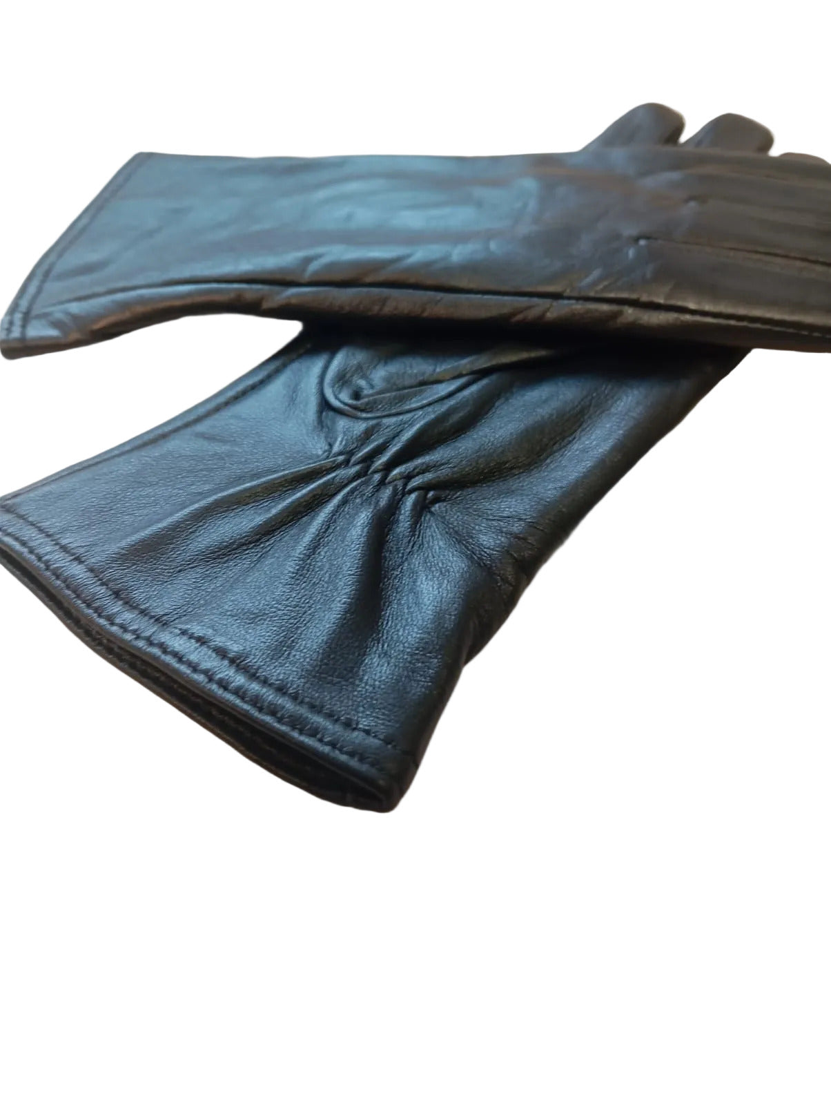 Black sheepskin leather gloves for women with soft lining, laid flat on a beige surface