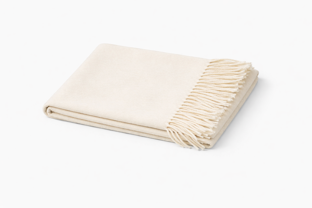 Folded thick wool scarf in ivory on a white background